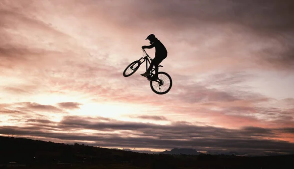 夕阳西下 泥土自行车和跳跃与行动在户外和运动在自然界的冒险或冒险 摩托车 轮廓和自由与训练 或在沙漠中与速度与驾驶有关的天空 — 图库照片