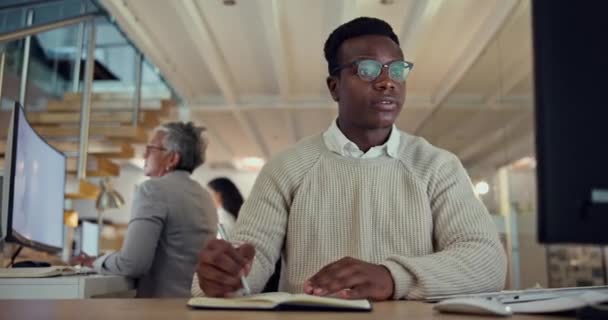 笔记本和研究 办公室里有个黑人商人坐在办公室里策划策略 与一名从事夜间工作的年轻雇员的计算机 信息和阅读 — 图库视频影像