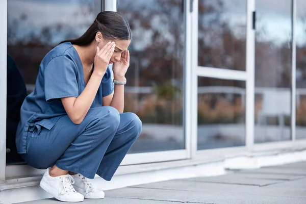 stock image Anxiety, doctor or a woman with a headache from healthcare, surgery mistake or death at a hospital. Sad, depressed and a tired female nurse with a migraine or burnout from medical career at a clinic.