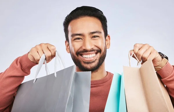 ショッピングバッグ スタジオの肖像画と幸せと男 小売製品と笑顔のためのファッションスプレー 販売または黒金曜日の選択 白人の背景に興奮した顔 プレゼント 幸せな男性顧客 — ストック写真