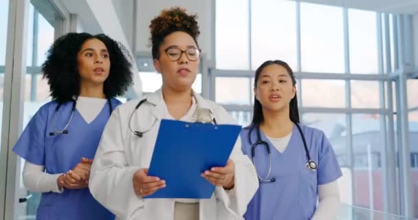病院の廊下の医師 チームワーク 女性は チェックリスト ツアーや職場での開発を示しています 医療グループ 新しい従業員と仕事への募集のための歓迎と現代のクリニックで一緒に歩く — ストック動画
