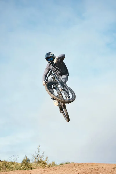Mountain, bike jump and person cycling on bicycle for extreme sports competition stunt or training in nature. Skill, contest and athlete workout or practice sky trick for fitness with mockup space.