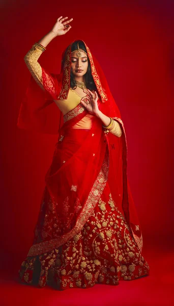 赤いスタジオの背景に伝統的なドレス ジュエリー お祝いのファッション ダンス インドの女性 文化的な衣装を持つ女の子とモデル 自信を持って踊りとルーチン — ストック写真