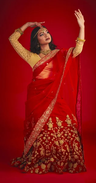 美丽的 穿着传统服饰 珠宝和宗教的印度女人在红色工作室的背景下跳舞 具有文化服装 舞蹈和时尚常规的女性人物 女孩和舞蹈家 — 图库照片