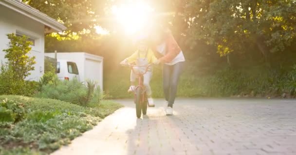 孩子和学习骑自行车在家里的乐趣技能 童年的支持和成长 快乐的妈妈 阳光和教骑自行车的年轻女孩在户外带着信任 玩耍和发展 — 图库视频影像