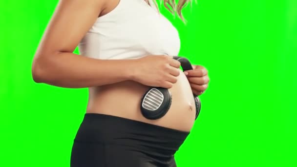 孕妇或耳机在工作室的绿色屏幕上的腹部 为成长或婴儿发育 怀孕期间的音乐 放松或母亲在胃部放音 以促进生育健康 — 图库视频影像