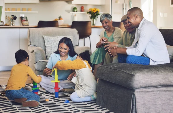 Big family, parents or happy kids on floor with toys for playing, creative fun or bonding at home. Development, smile or children enjoy building blocks games to relax with mom, dad or grandparents.