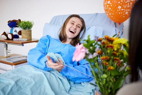 病院の患者と支援を受けて回復中の女性とベッドで花を持つ訪問者 医療保険 サービスの良い人 家族やケアはすぐに気球を取得します — ストック写真