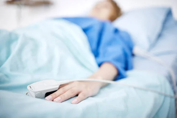 診療所でのIcu手術のための病院のベッドで人 手や睡眠 はれもの 病気の患者が横たわっているか 医療や健康回復のための緊急治療室で休んでいる — ストック写真
