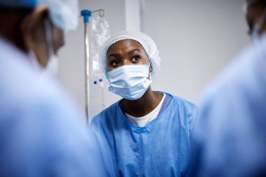 Ameliyat, takım çalışması ya da hastane kliniğinde acil durum, kaza ya da sağlık sigortası için maskeli cerrahlar. Doktorlar, tıbbi ya da Afrikalı hemşireler, cerrahi işbirliği içinde ameliyathanede yardımcı olurlar..