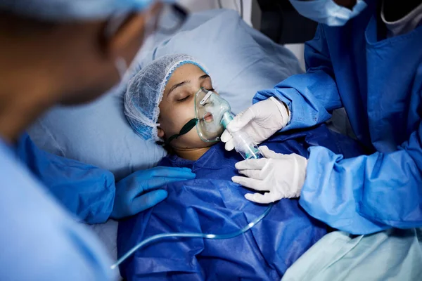 病院のベッドや酸素マスク 呼吸器や医療回復のための操作を持つ病気の女性 緊急時の換気のための呼吸器を備えた医療外科医 麻酔または患者 — ストック写真