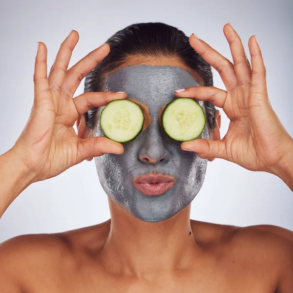アンチエイジング顔の治療のため スタジオでモデルの女性と一緒にグレーの背景に目 キュウリ マスク 顔に化粧土を使っている若い女性との顔 スキンケア 食べ物 — ストック写真