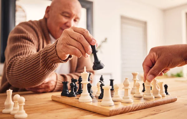 Senior man, home and chess for games, competition and focus with friends, strategy and problem solving. Elderly person, hands and board for contest with mindset, excited smile and moving at table.