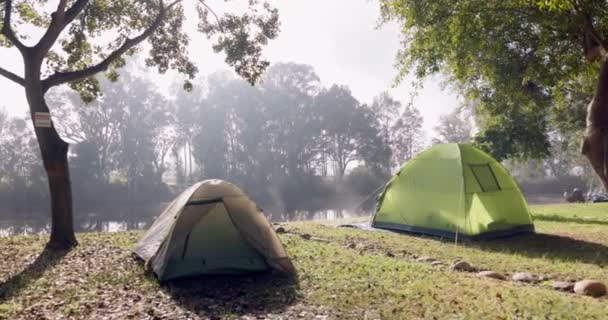 野外露营的帐篷 夏天的旅行和周末假期 在河边或水边的草地上 为了探险 度假或在树林中放松一下 要保持镇定 要有景观 要有远足的装备 — 图库视频影像