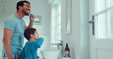 Baba, çocuk ve diş hijyeni öğretirken ya da öğretirken aile banyosunda diş fırçalama. Sağlık için diş fırçası ve diş macunu kullanan bir adam ve çocuk aynada ağız temizliği ve sağlıklıdırlar..