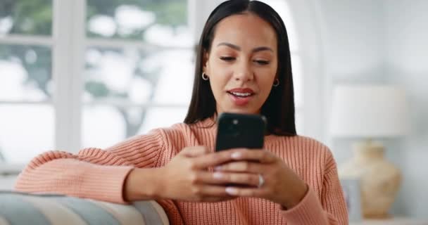 笑着在沙发上的智能手机上打字 为社交媒体贴文 有趣的迷因或在线聊天 快乐的女性 通过手机 手机搜索或数字联系来放松和发短信 — 图库视频影像