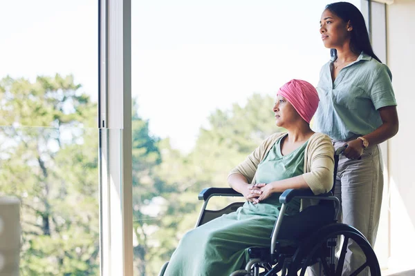 医療や医療支援を考えながら 窓辺のシニア女性の癌 車椅子や娘 障害のある高齢者 患者または介護者のヘルプ将来のアイデアを家庭で — ストック写真