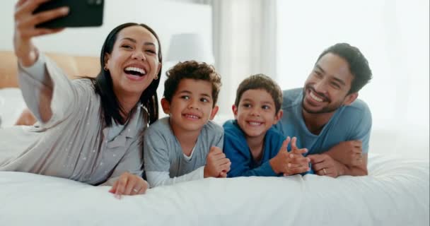一家人自私自利 欢笑着 在家里的卧室里寻觅着回忆 快乐和喜剧在一起 爱和一个年轻的母亲 父亲和孩子 早上在床上拍照以获得照顾和乐趣 — 图库视频影像