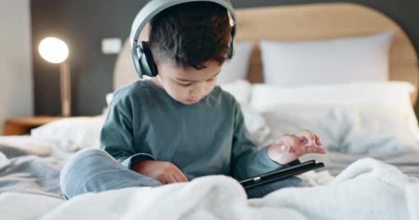 孩子和平板电脑在卧室里的耳机在线游戏 看电影和玩教育应用在晚上 数字技术和听多媒体 音乐和流媒体漫画 — 图库视频影像