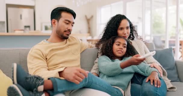 快乐的家庭 父母和孩子们带着遥控器在客厅里看电视 带着关心和爱心 多种族的男人 女人和女孩坐在家里的沙发上玩乐 享受高质量的时光 谈情说爱或看电影 — 图库视频影像