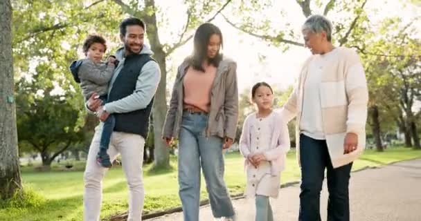 家族が一緒に新鮮な空気 会話のための公園を散歩しています 緑の庭で時間を過ごすために話している両親や祖母と幸せな笑顔と子供たち — ストック動画