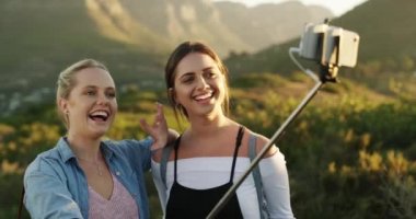 Kız arkadaşlar, el sallayın ve selfie çekin, doğa yürüyüşüne telefonla çıkın ve dağlarda dolaşın. Gençler, kadınlar ve sosyal medya uygulaması için mobil resim ve tatilde mutluluk ve gülümsemeyle.