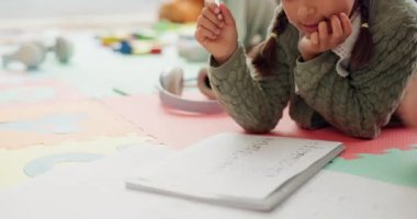 Girl kid, father and homework on floor, writing or helping hand for for education, teaching or support. Dad, young child and advice for math assessment, learning or studying with book in family home.