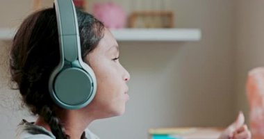 Children, face and headphones with a student girl distance learning during remote home schooling in her bedroom. Kids, education and thinking with a young female child listening to an online lesson.