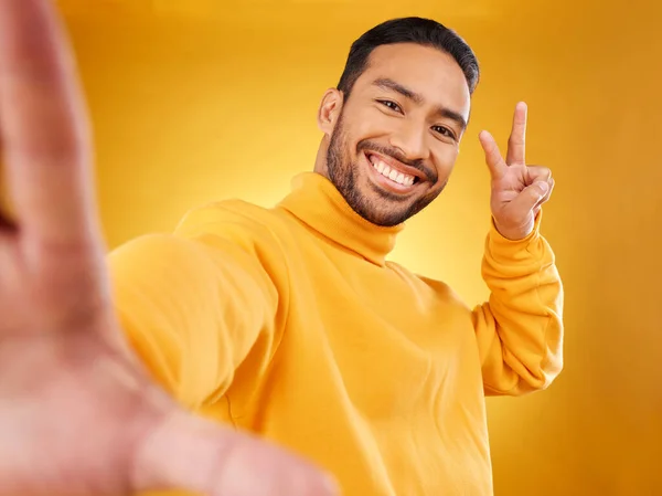 和平的标志和一个男人幸福的肖像在工作室与手 感情和微笑 黄色背景下的男性亚洲时装模特 对社交媒体形象的更新有着积极的心态 — 图库照片