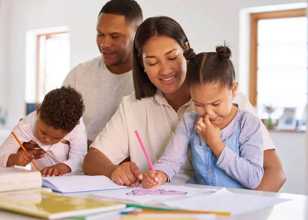 Family, parents help their children with homework and books on desk at their home. Support with writing or reading, education or learning and woman with man helping their kids color in a book.