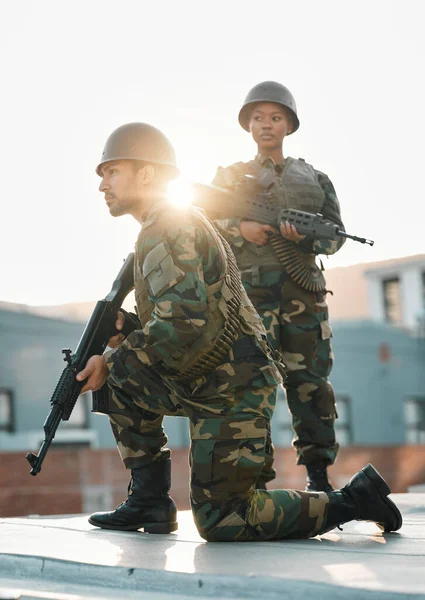 Army, training and people with gun, defense or power on rooftop for aim, shooting or practice. Military, weapon and black woman with man soldier and sniper rifle for war, target or protection team.