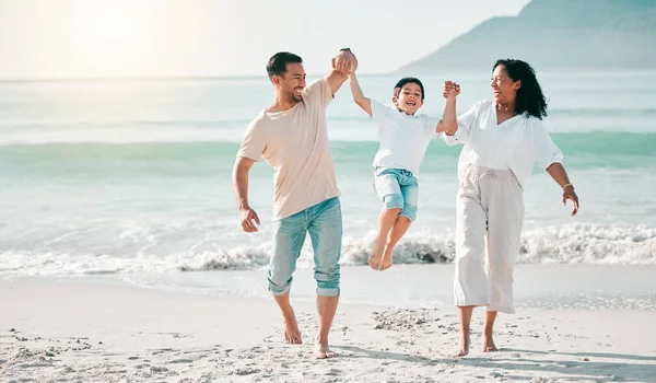 Holding hands, dad or mother playing child at beach with a happy family for holiday vacation travel in nature. Jump, parents or mom lifting child with dad walking at sea or ocean bonding together.