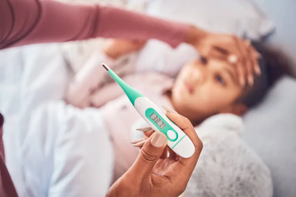 Sick child in bed, mother and thermometer for fever, virus and flu with illness, care and health. Mother, kid and woman check temperature, home or support with fever, love, forehead or medical issue.