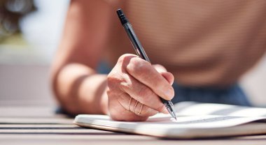 Yazın yazar olarak ilham almak için açık havada oturan bir kadın yazarla el yazısı ve kitap. Günlüğünü veya günlüğünü yazmak için kalem kullanan bir kadınla fikir, planlama ve defter..