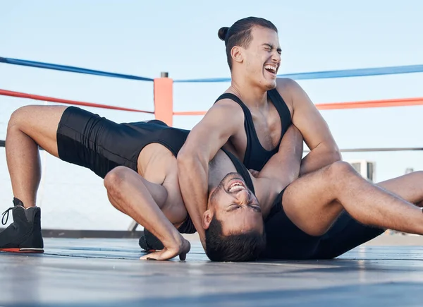Men, wrestling and competition in a ring, mat or athlete winning in a tournament, match or training on floor of an arena. Fighting, match or championship gym with people grappling together for sport.