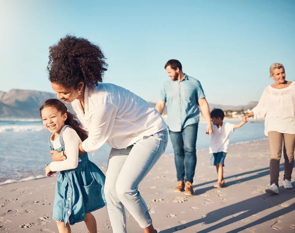 Happy, child and a mother running at the beach on a family vacation, holiday or adventure in summer. Young girl kid playing with a woman outdoor with fun energy, happiness and love by the ocean.