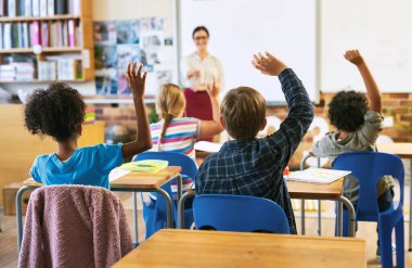 Eğitim, sınıfta bir grup çocukla soru sorun ve cevap vermek için ellerini kaldırın. Öğrenim ya da destek, çeşitlilik ve öğretmenlik okul binasında birlikte genç öğrencilerle birlikte..