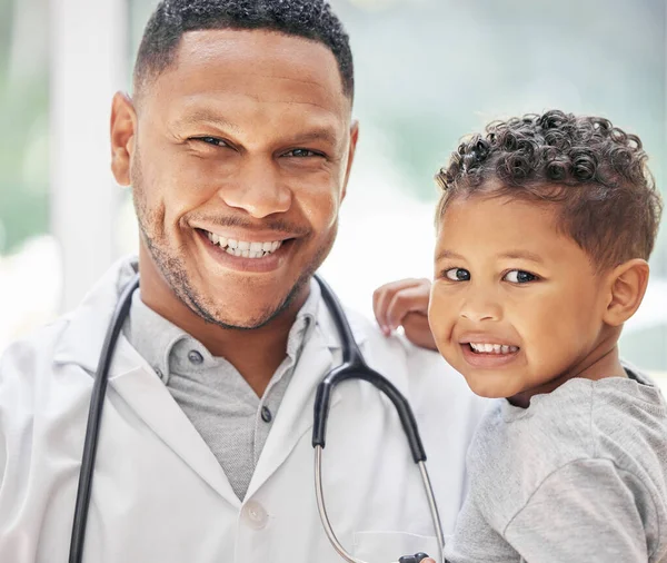 Pediatrician, child and happy portrait for health care in hospital with a smile at a consultation. Face of black man or doctor and kid patient for medical help, family insurance or development check.
