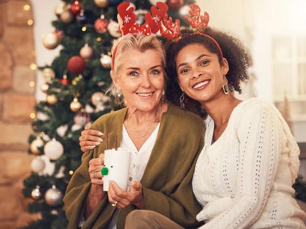 Portrait, christmas and blended family with a woman and daughter in law together in a home during the festive season. Smile, love and diversity with happy people in a house for december celebration.