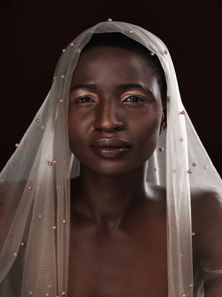 Whatever youre facing, face it with confidence. Studio portrait of an attractive young woman posing in traditional African attire against a black background