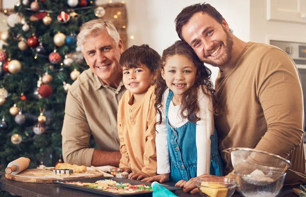Christmas, portrait and family baking cookies in home, bonding and together. Xmas, cooking food and face smile of grandfather, dad and children with love at party, celebration and winter holiday.