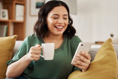 Kanepede oturan, telefon, kahve ve gülümseyen, e-posta ya da sosyal medya memeleri okuyan bir kadın. Ağ kurmak, cep telefonu ve mutluluk, kız koltukta dinlenmek, sohbet etmek ve internette mesaj aramak