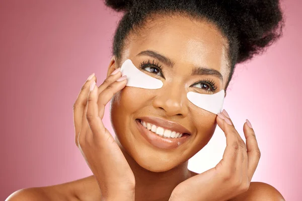 スキンケア 黒人女性 目にパッド 化粧品 皮膚科 ピンクの背景 コラーゲン製品 健康な肌の輝き スタジオでのケアのための幸せなモデルアイパッチ — ストック写真