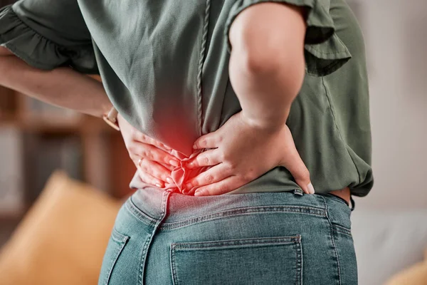 Red, back and pain of woman with injury problem, health risk or muscle inflammation at home. Closeup of uncomfortable female person with glow on spine of bad posture, backache and stress of body.