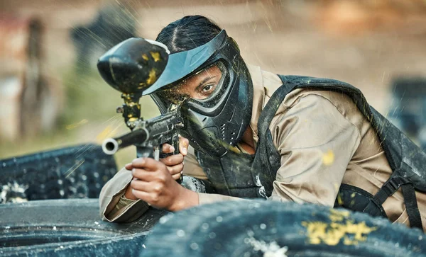 Paintball, sports and woman in action with gun for tournament, competition or battle in park. Soldier, military and female person shooting in outdoor arena for training, adventure games and challenge.