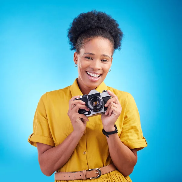 Photography, portrait and black woman with camera, smile and isolated on blue background, creative artist job and talent. Art, face of happy photographer with hobby or career in studio for photoshoot.
