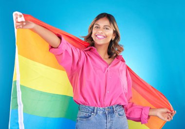 Lgbtq bayrağı, portre ve mavi stüdyo arka planında gururu ve mutluluğu olan bir kadın. Eşcinsel topluluğunun sembolü olan kadın, müttefik veya model, eşitlik veya özgürlük ile cinsiyet değiştirme hakları.