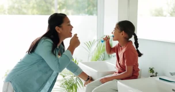 教师或在浴室里的孩子一起刷牙 以便在家里学习或发展孩子 快乐的妈妈或女孩用牙刷或牙膏清洁口腔 以促进牙齿健康 — 图库视频影像