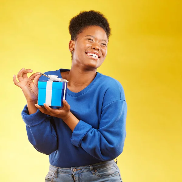 Gift, winning and happy black woman with a surprise isolated in a yellow studio background for a birthday. Giveaway, box and excited person to celebrate, party and holiday as a winner with happiness.