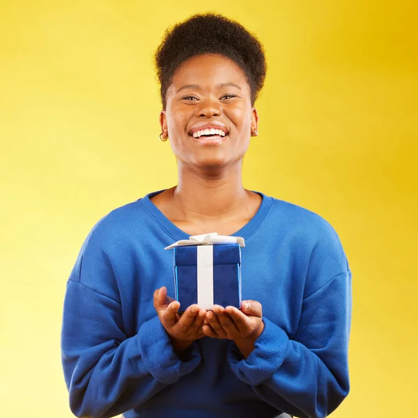 Gift, birthday and portrait of black woman with a surprise happy isolated in a yellow studio background with a present. Winning, box and excited person to celebrate, party and holiday as a winner.